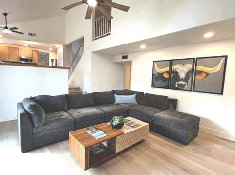 Large living room has an extra large sectional, individual chairs, big screen smart TV, board games, two different areas to charge your devices.