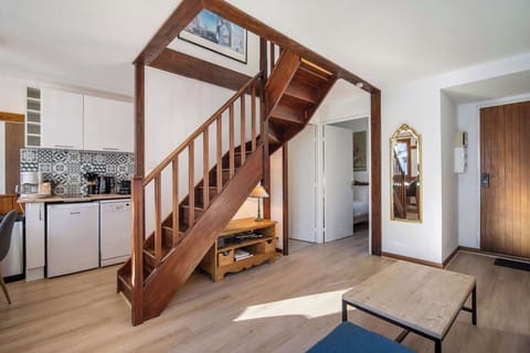 Spacious living room with comfortable sofa, sunlight, and warm chalet ambiance — relax after skiing.