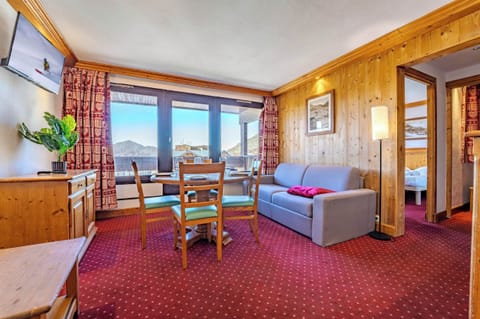 Bright living room with mountain views and dining space—steps from the pistes and lifts; cozy après-ski moments in Val Thorens, Les Belleville.