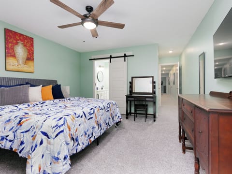 Spacious primary bedroom featuring a comfortable king bed, dedicated dresser, smart TV, vanity and plenty of room to unwind after a busy day. Enjoy direct access to the private balcony and ensuite bathroom.