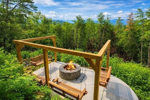 Scenic fire pit with swing seating overlooking peaceful mountain and Dolly's favorite view. Perfect for evenings under the stars!