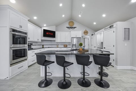 Fully stocked open concept kitchen with bar seating for 6