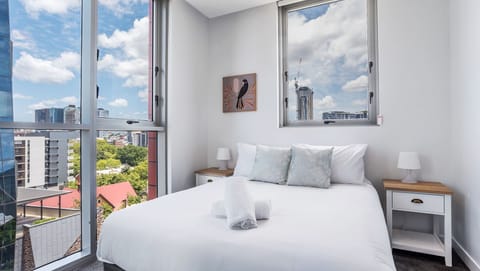 Master bedroom with plush bedding and skyline outlook