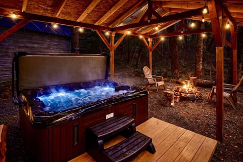 Cozy outdoor retreat with glowing hot tub and fire pit ambiance