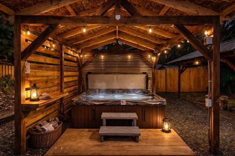 Cozy outdoor hot tub retreat under warm, glowing lights
