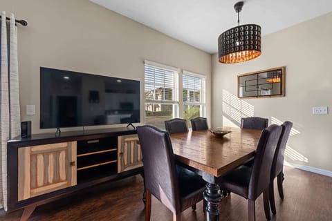 Dining area with a rustic wooden table and leather chairs illuminated by natural light.