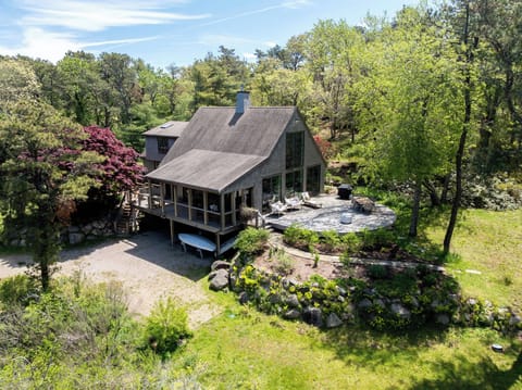 Aerial view of Marshlight Retreat highlights its private setting, spacious deck, wooded grounds, and peaceful North Chatham location.