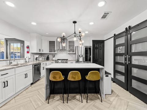 Your modern kitchen awaits with marble island seating, premium appliances, and stylish gold accents for memorable meal prep moments.
