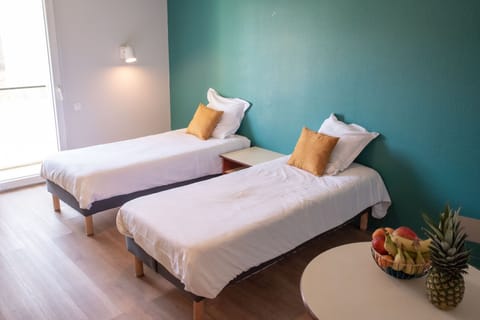 A bright studio layout with twin beds, offering a comfortable space to relax and recharge.