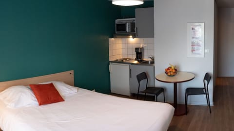 A bright studio layout that combines sleeping and dining space in a comfortable, open setting.