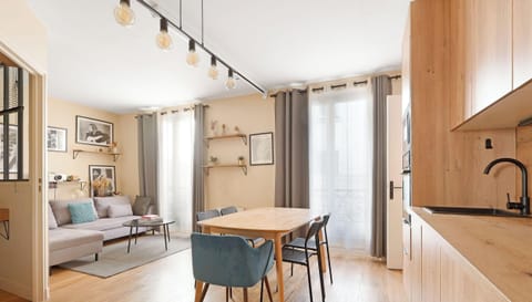 Espace de vie lumineux avec canapé confortable, coins repas et cuisine équipée