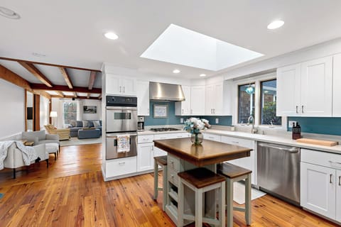 Skylit kitchen with island seating and stainless appliances