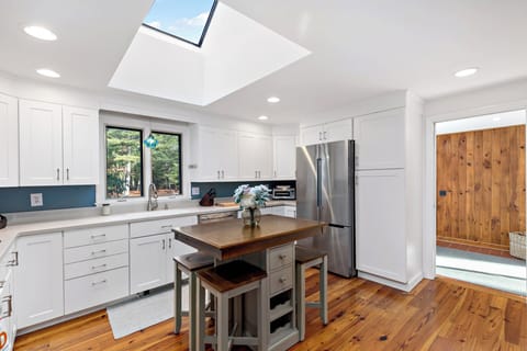 Bright kitchen with ample cabinets, full size fridge, and prep island