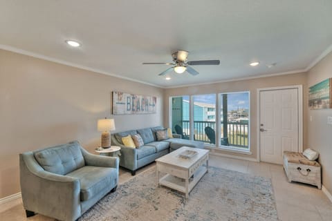 Bright coastal living room with plush seating and balcony access