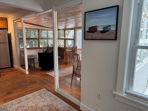 Kitchen open to enclosed porch with views, seating and dining room