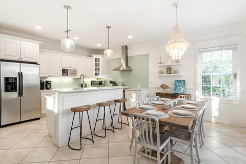 Bright coastal kitchen and dining space welcomes your group with ease.
