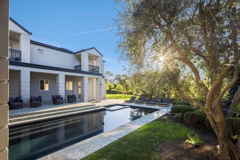 Stunning backyard view with a beautiful pool surrounded by lush greenery.