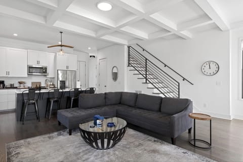 Living room view highlighting the sleek black metal staircase and open floor plan