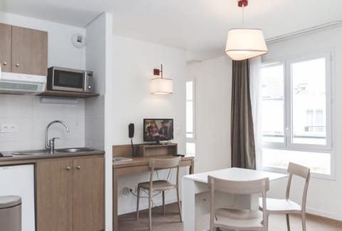 The kitchenette is neatly arranged next to the dining table for easy everyday use.