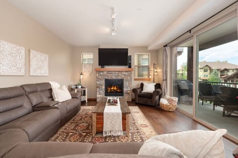 Spacious living room with fireplace, smart TV and walkout patio with dining area