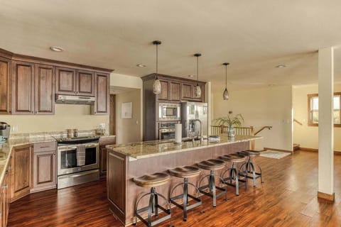 Fully equipped gourmet kitchen featuring premium granite countertops, rich wood cabinetry, and sleek stainless steel appliances.