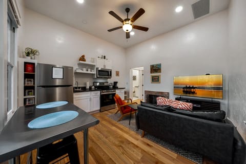 Cozy, open concept space with kitchen, living room area with electric fireplace, and dining table for two