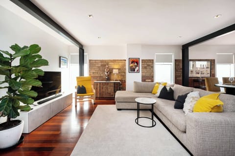 Open plan living area comes with modular lounge with chaise and smart TV in this great warehouse conversion
