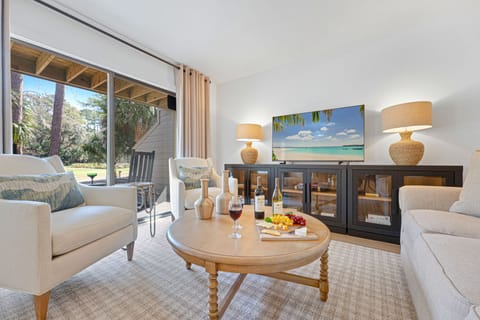 Relax in a light-filled living space with sliding glass doors opening to the first floor deck overlooking the course.