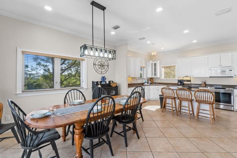 Your spacious dining area flows seamlessly into a bright kitchen, perfect for cooking and gathering around the warm wooden table.