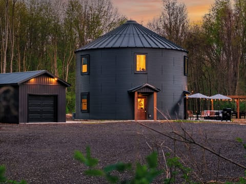 Modern silo retreat in the woods with grill, pergola patio & string lights