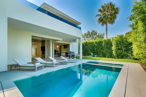 Sun-filled backyard with pool loungers and updated landscaping for all-day relaxation