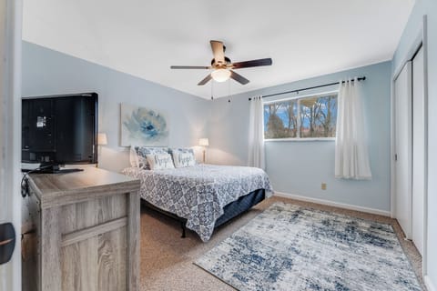 Comfortable queen bed, TV, natural light and a pleasant neighborhood view.