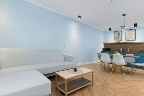 Bright living room with sofa, dining table, and open kitchen.