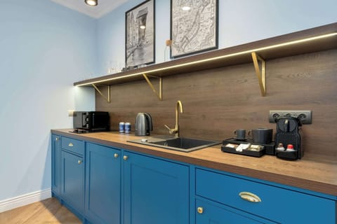 Fully equipped kitchen with blue cabinets and worktop.