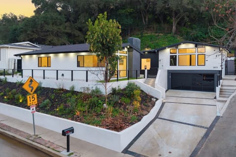 Striking modern exterior with lush landscaping, hillside privacy, and a sleek arrival that sets the stage for a refined LA stay.