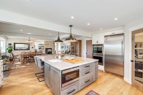 Your gourmet kitchen features a spacious island, stainless steel appliances, and pendant lighting, perfect for cooking memorable meals together.