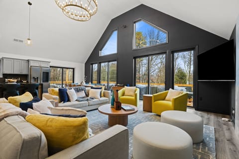 Gather in the sun-filled living room with soaring A-frame ceilings and views of the wraparound deck