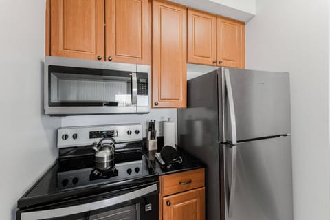 Experience a beautifully designed kitchen with rich wooden cabinets and sleek stainless steel appliances, ideal for preparing meals during your stay. The dark countertops add a sophisticated touch, making cooking enjoyable.