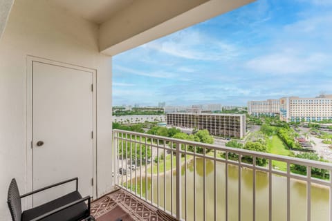 Step onto your private balcony to take in stunning views of lush greenery and tranquil waters. The sleek metal railing and cozy chair invite you to relax and savor the fresh air and vibrant atmosphere.