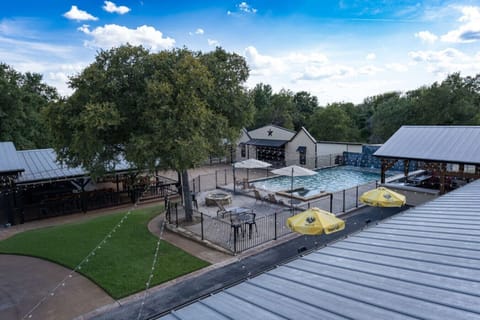 The pool and hot tub are located just off the deck, with sun loungers, umbrellas, and seating.