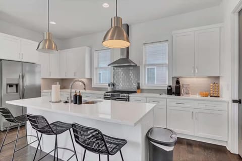 Open-concept kitchen with quartz counters, gas range, and stainless appliances. | Unit A