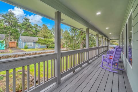Unwind on your private covered porch with charming purple Adirondack chairs, perfect for morning coffee or evening relaxation.