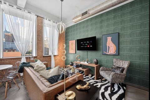 Living Room/Dining: Bright open living space with large windows, skyline views, and stylish décor—perfect for relaxing, dining, and enjoying Dallas.
