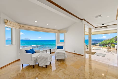 Endless ocean views from your elegant living space, where turquoise waters stretch to the horizon beyond floor-to-ceiling windows.