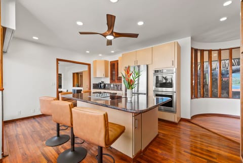 Your modern kitchen features sleek granite counters, stainless steel appliances, and a breakfast bar where you can enjoy morning coffee.
