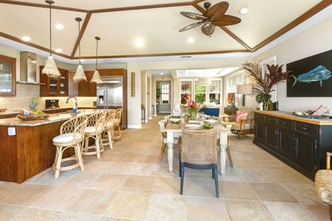Step into your tropical-inspired kitchen where warm wood tones and modern appliances create the perfect space for morning coffee and vacation meals.