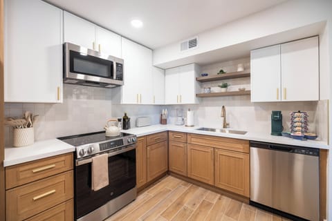 Your fully equipped kitchen awaits with modern appliances, warm wood cabinetry, and thoughtful touches that make cooking feel like home.