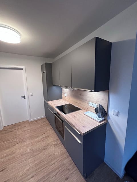 Modern kitchen with wooden countertop and refrigerator.