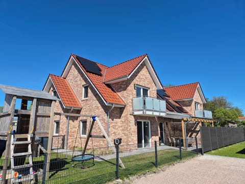 Exterior view of a modern holiday home with playground
