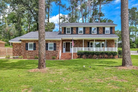 Welcome to your charming retreat! A classic brick exterior and lush green lawn greet you, perfect for arriving in style.